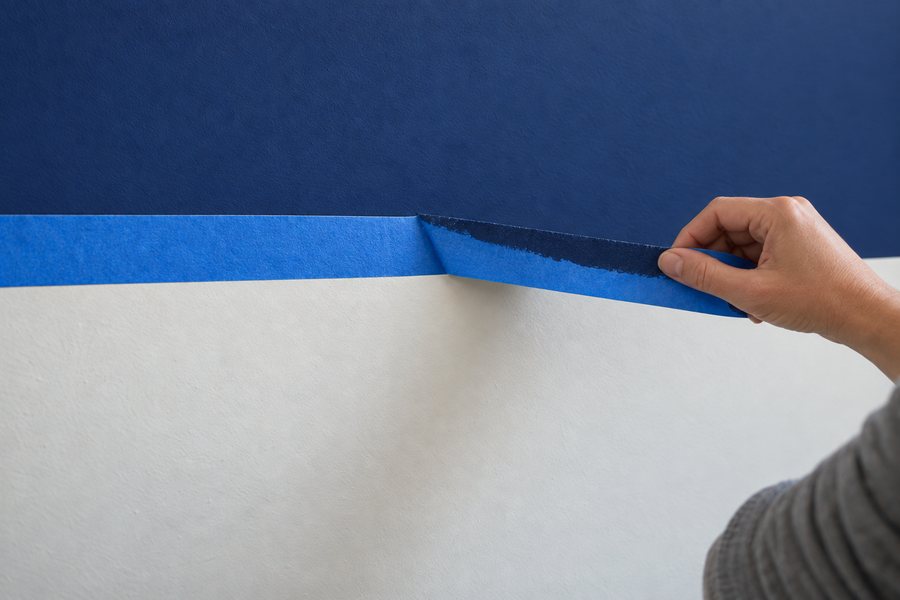 Tape being peeled away to show a sharp line between navy and white